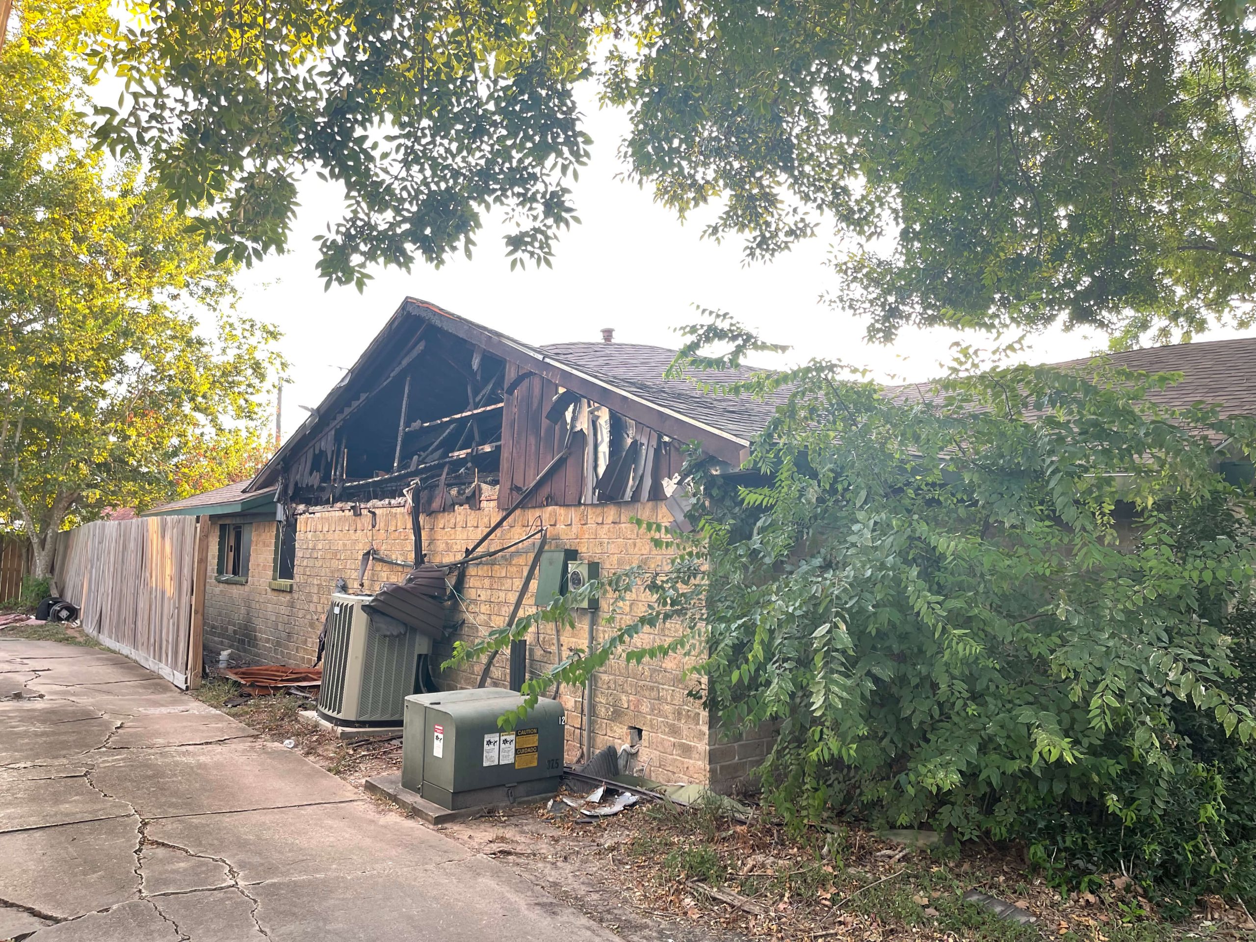 Exterior of fire-damaged Sagecanyon Dr home in Sagemont, Houston TX near Pearland, closed for cash as-is by Volcan Property Buyers