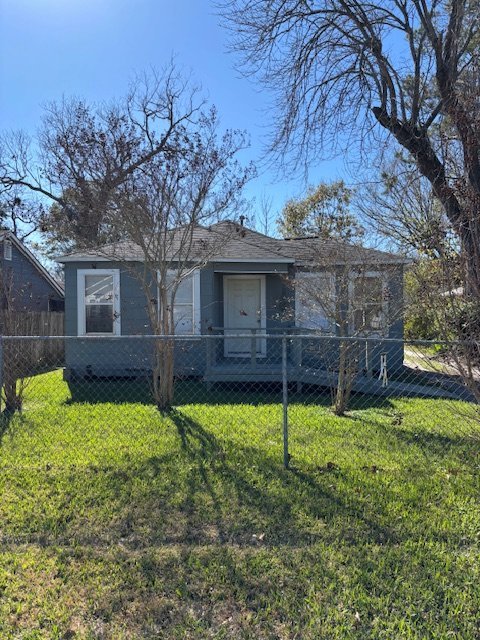 Front of distressed gray cottage bought for cash as-is in Baytown TX