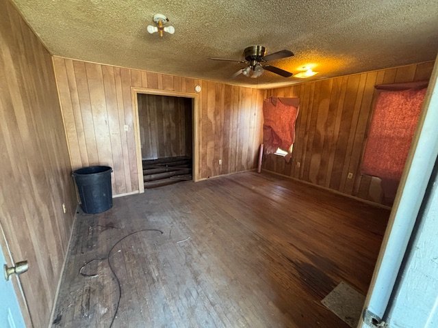 Vacant wood-paneled room with worn floors in Baytown TX home purchased as-is for cash