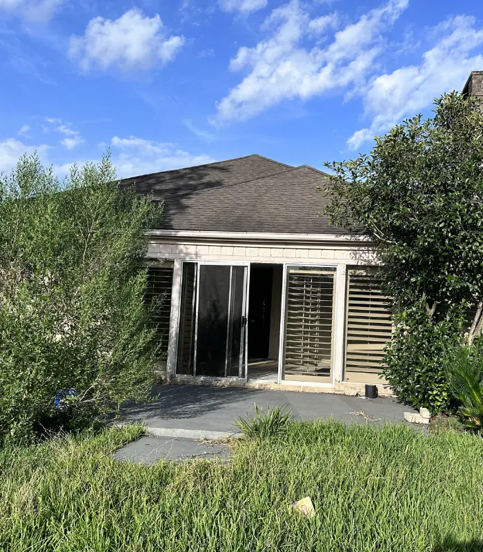 Older Baytown home with overgrown landscaping and deferred exterior maintenance