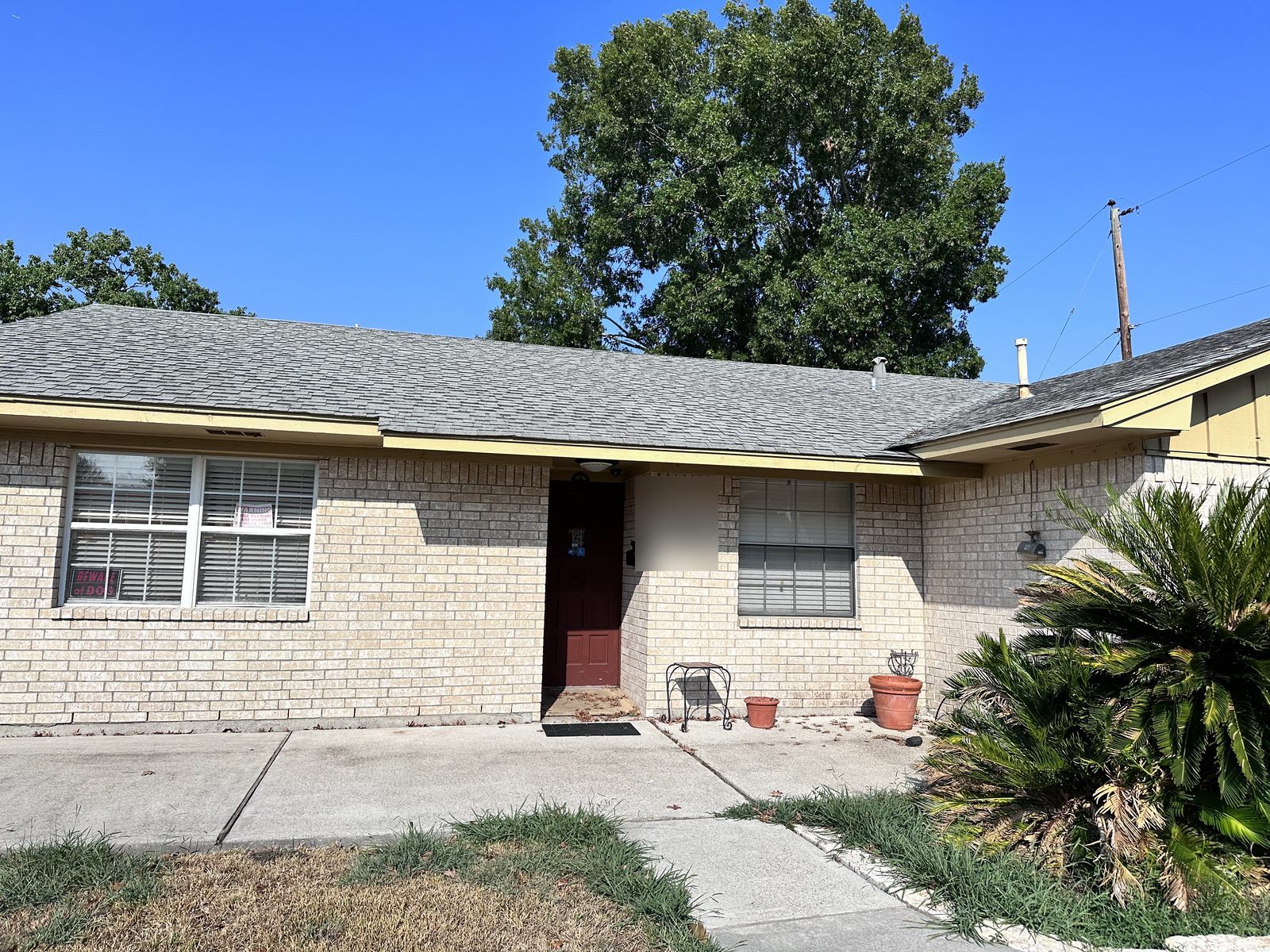 Front exterior of neglected inherited brick home bought for cash as-is in Glen Arbor, Baytown TX