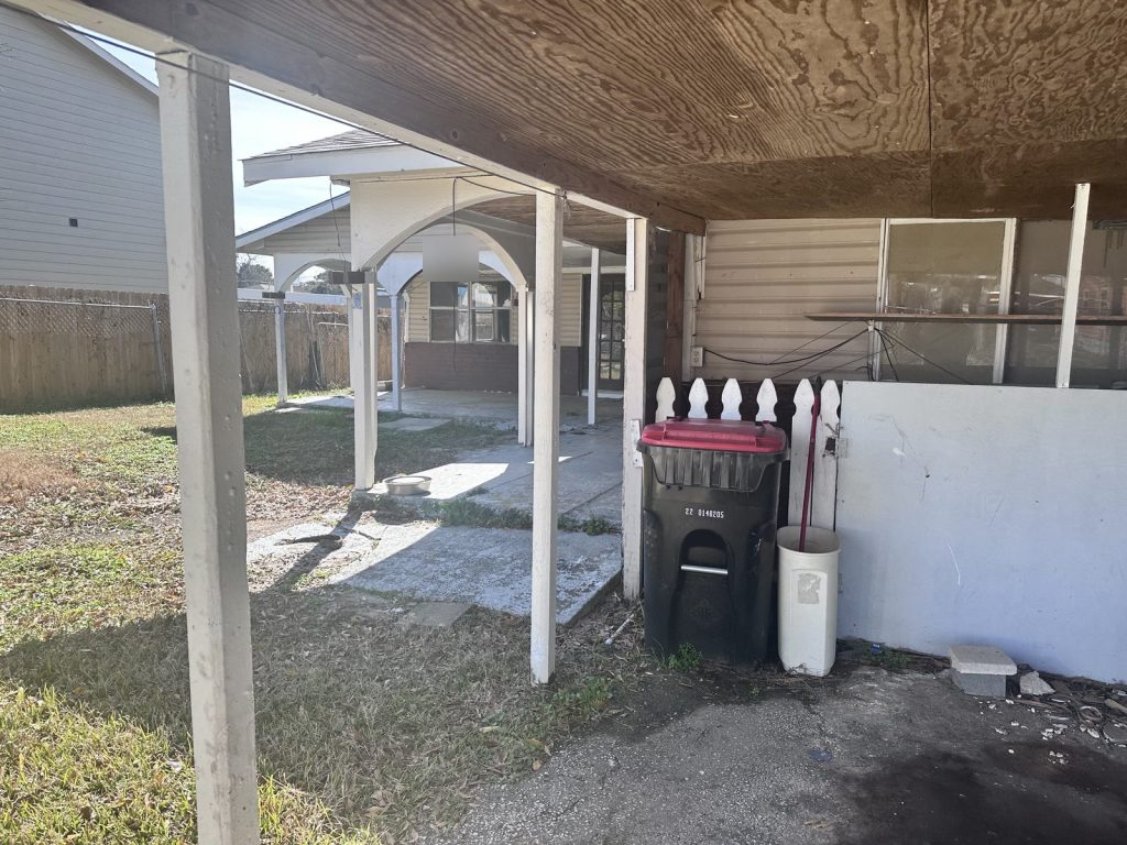 Carport of vacant home bought for cash by Volcan Property Buyers in Baytown TX