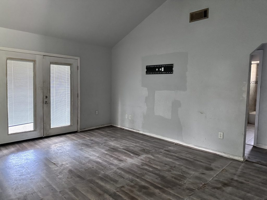 Empty living room of abandoned inherited home purchased as-is by cash home buyers in Baytown TX
