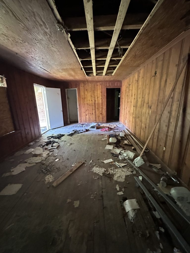 Gutted living room with collapsed ceiling in distressed Baytown TX home purchased as-is for cash