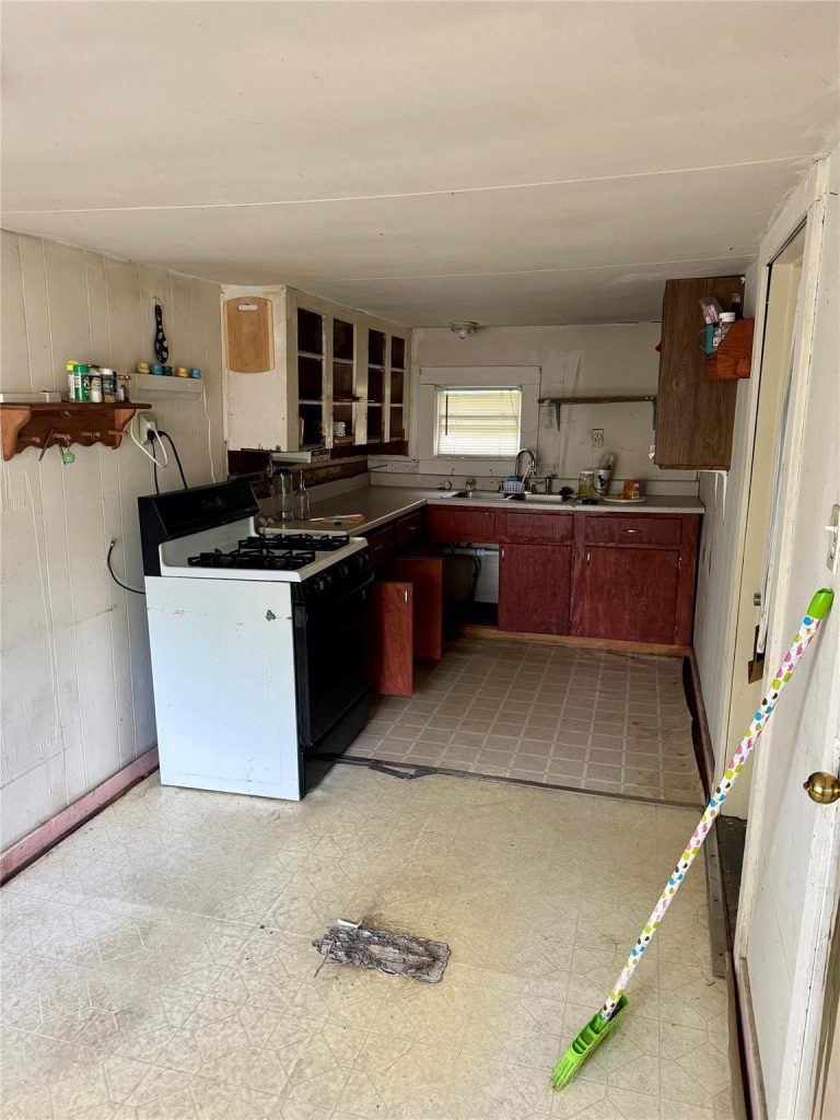 Dated kitchen with old cabinets in as-is Baytown TX home bought for cash