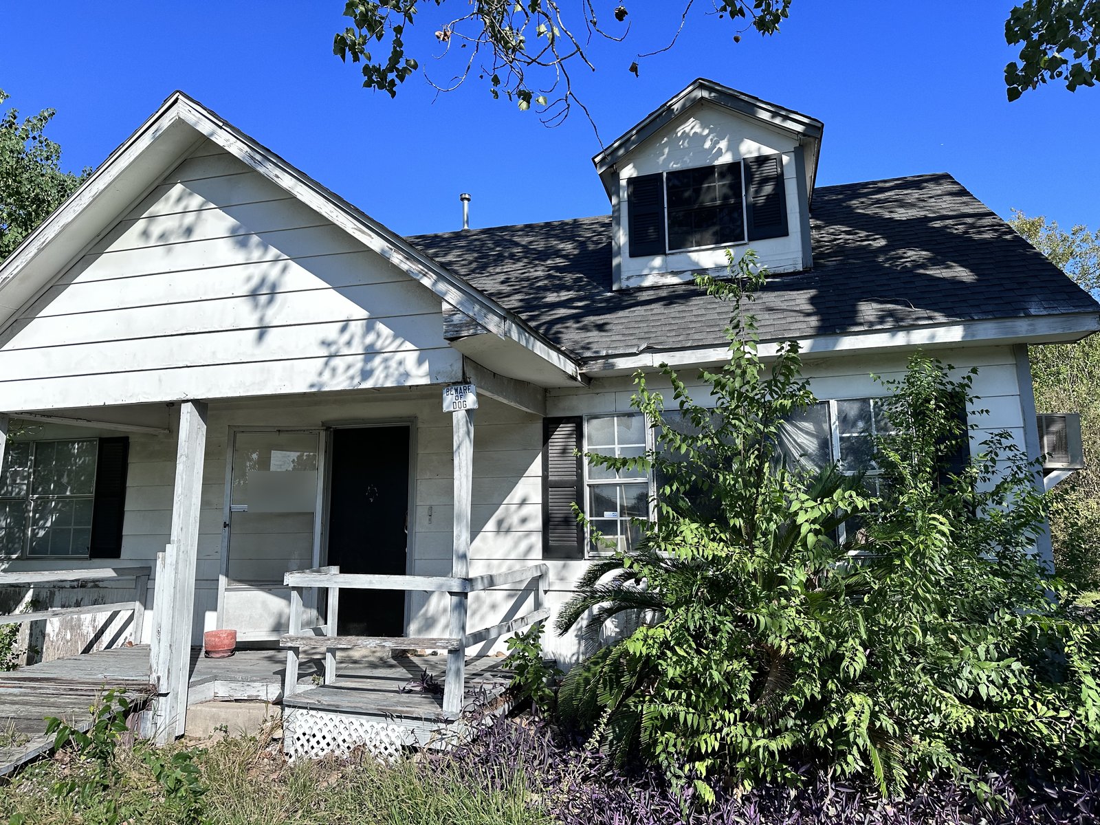 Front exterior of an abandoned, termite-damaged home in Carverdale near Houston/Cypress