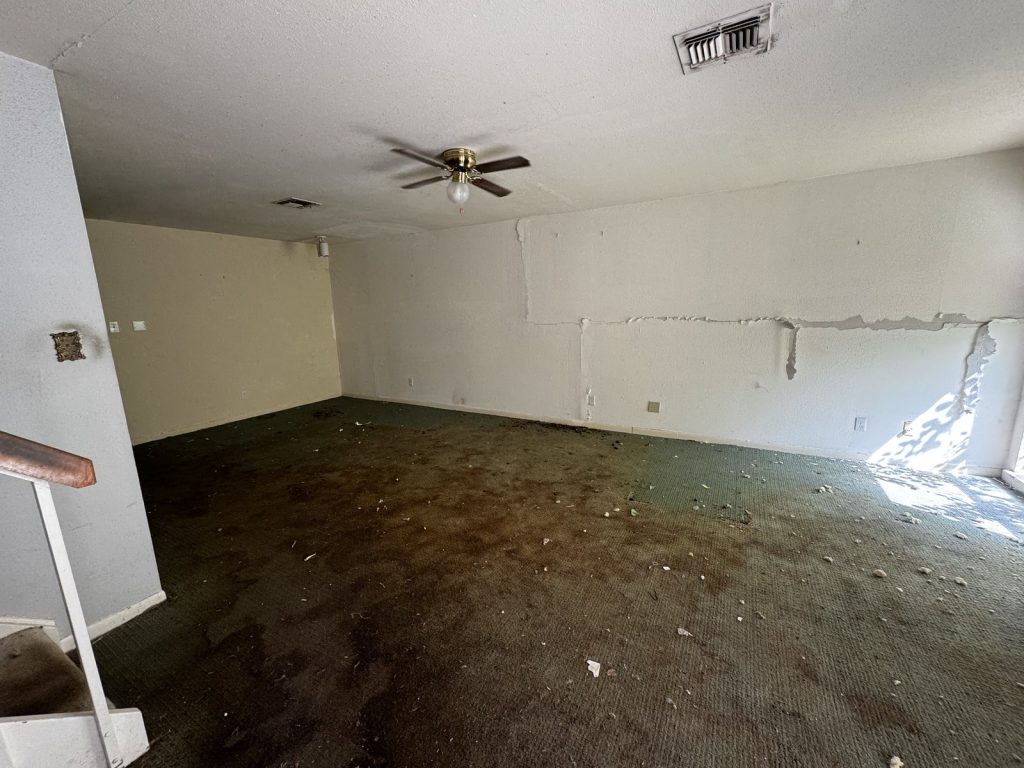 Damaged carpet in a vacant living room at a Grogan's Mill townhome in The Woodlands, TX