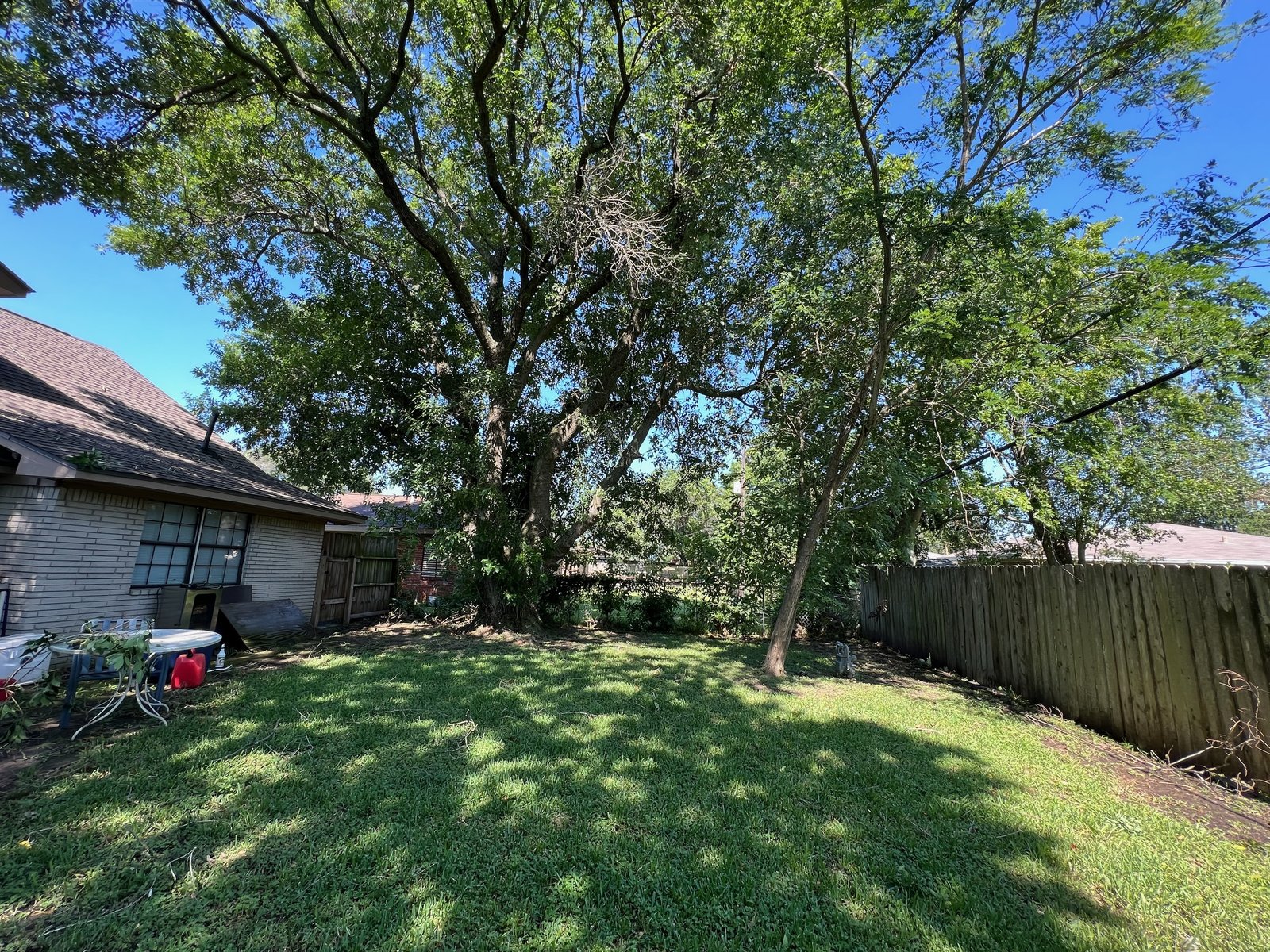 Rear elevation and shaded back yard of as-is rental home bought for cash in North Texas City, Texas City TX