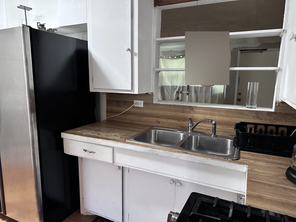 Dated kitchen with worn worktop in as-is rental home bought in La Marque TX