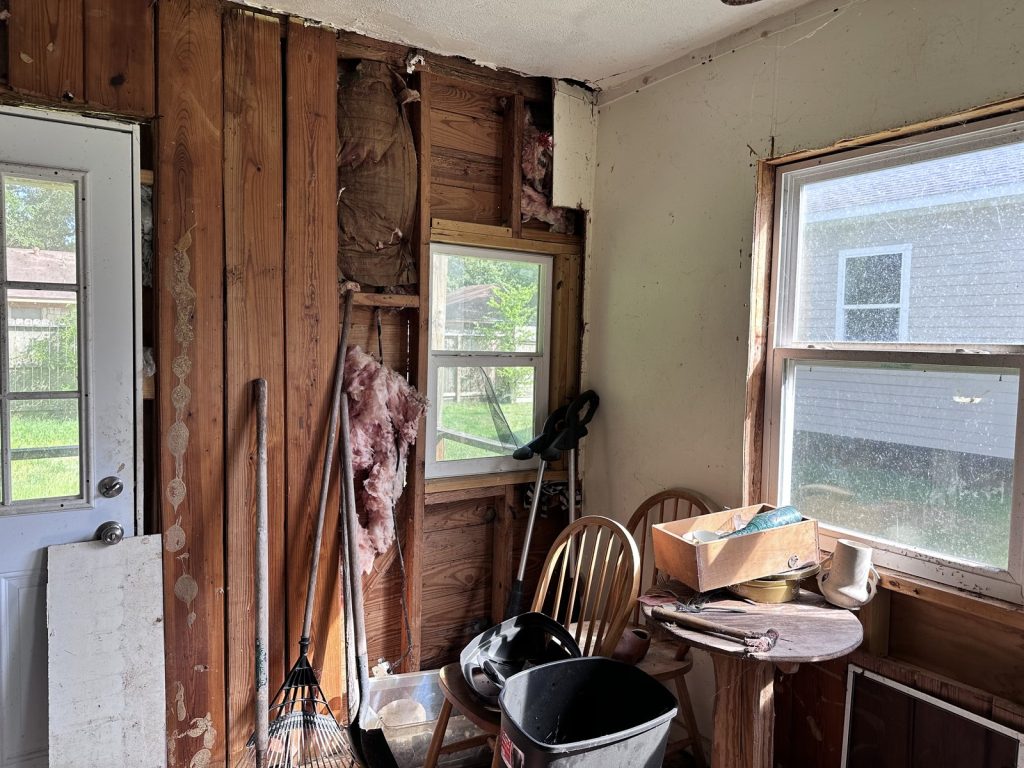 Wall stripped to the studs with loose insulation in as-is home purchased in La Marque TX