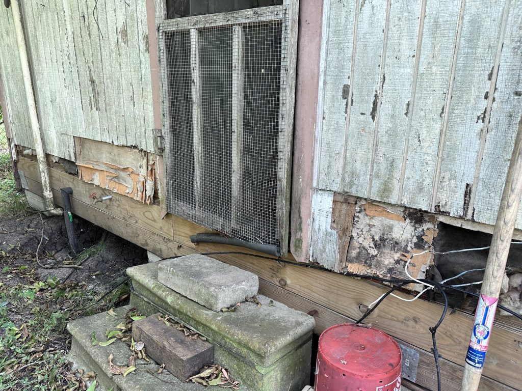 Severe timber rot at the base of an outbuilding on as-is property purchased in La Porte TX