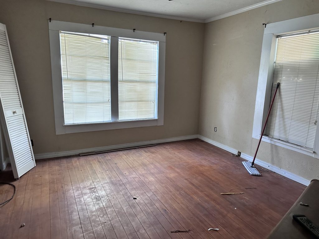 Empty room with original timber floors in as-is home bought in Alvin TX