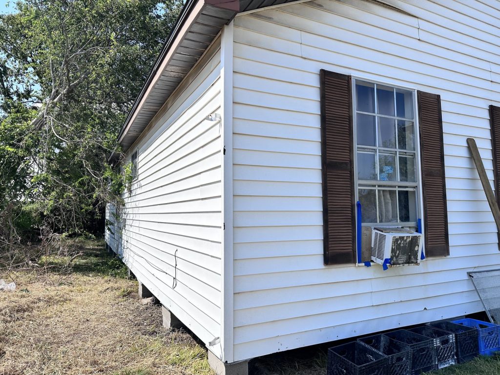 Side exterior view of an inherited home in Groveland Terrace, Houston TX bought for cash by Volcan Property Buyers
