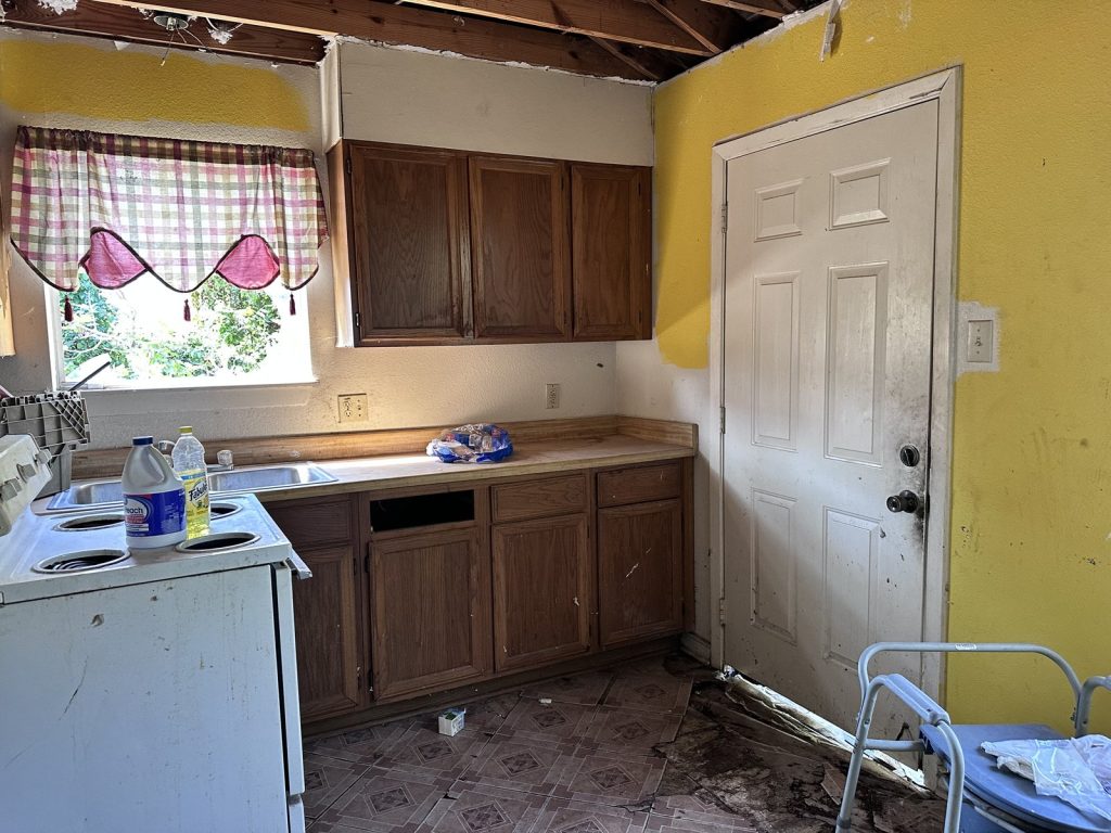 Water-damaged kitchen inside a vacant Groveland Terrace, Houston home bought as-is for cash