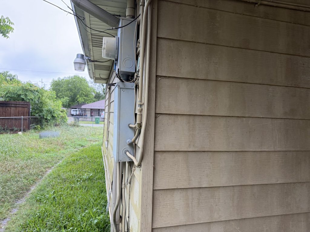 Weathered side exterior of aging rental home purchased as-is in South Park, Houston TX