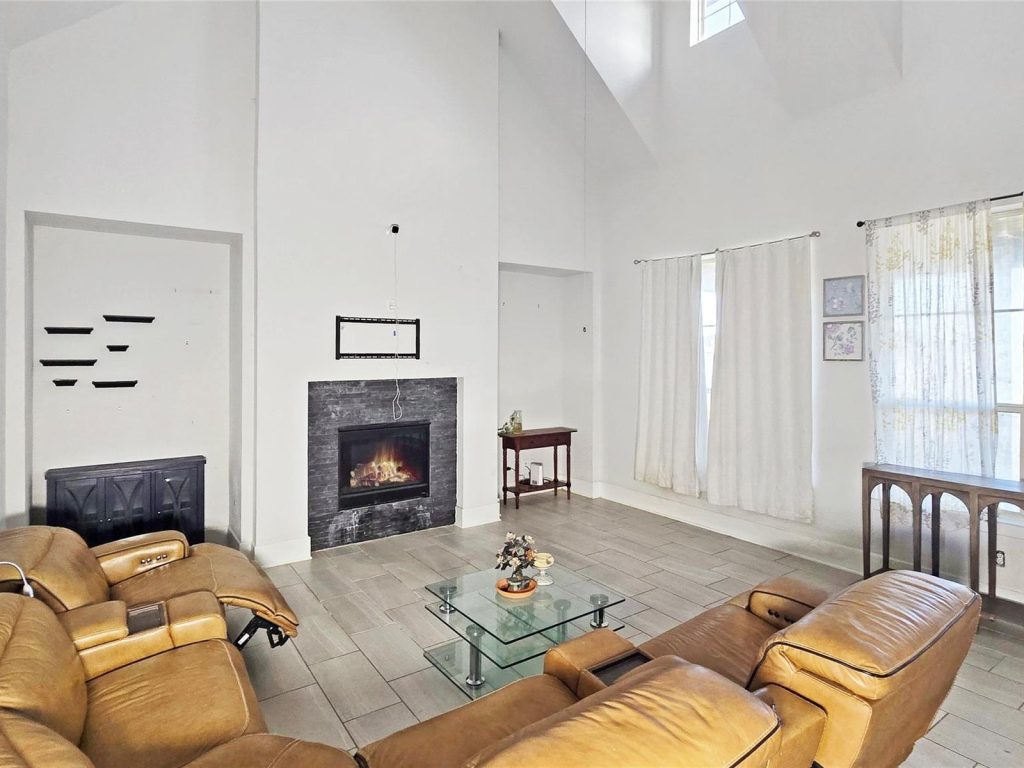 Vaulted living room with fireplace in an Elyson, Katy TX home purchased by Volcan Property Buyers