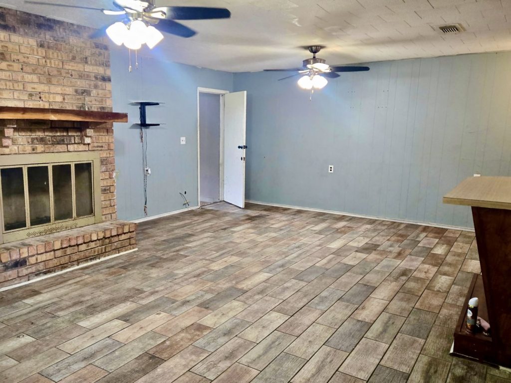 Empty living room needing repairs in a tired-landlord rental in East Houston, TX