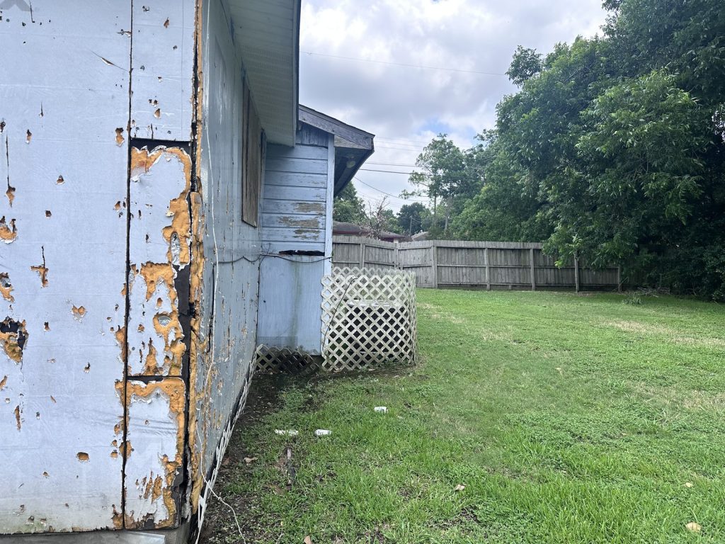 Damaged siding on structurally distressed Houston TX home bought by cash home buyers