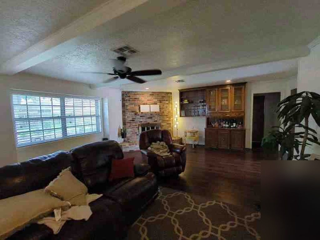 Living room with brick fireplace and wet bar at a Sugar Creek home in Sugar Land, TX