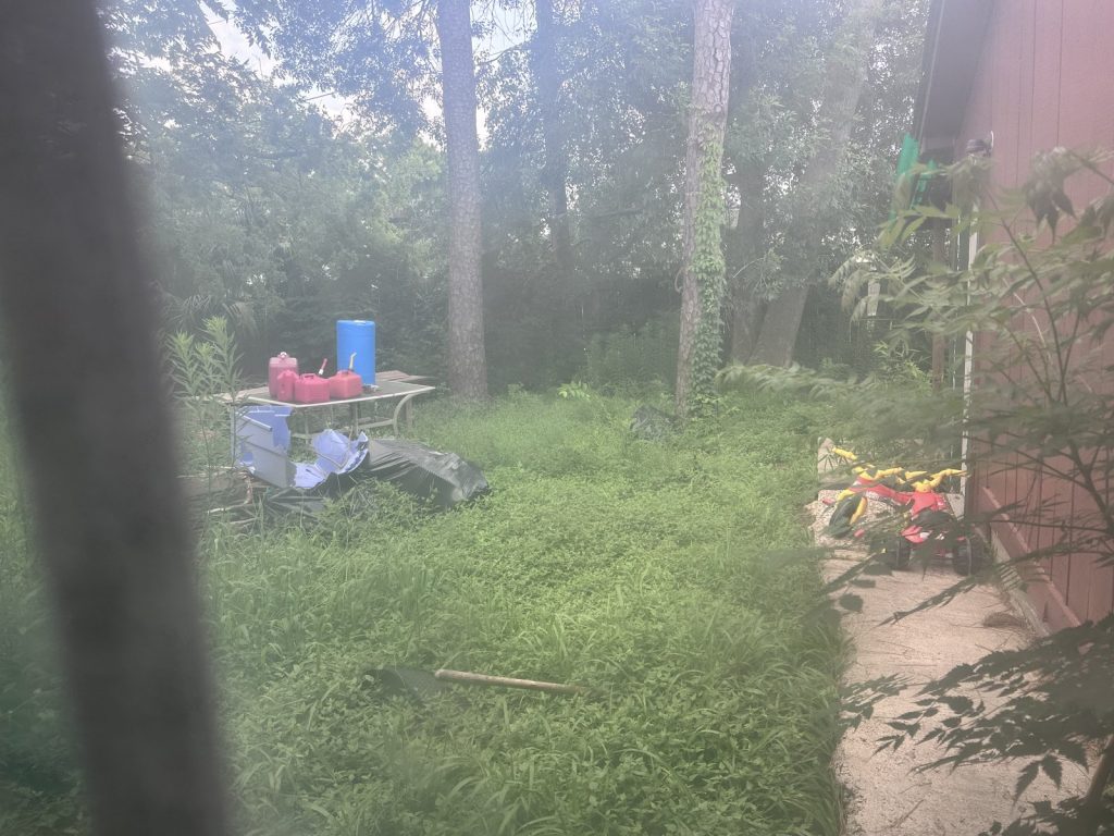 Overgrown backyard at an inherited Nassau Bay property sold as-is for cash