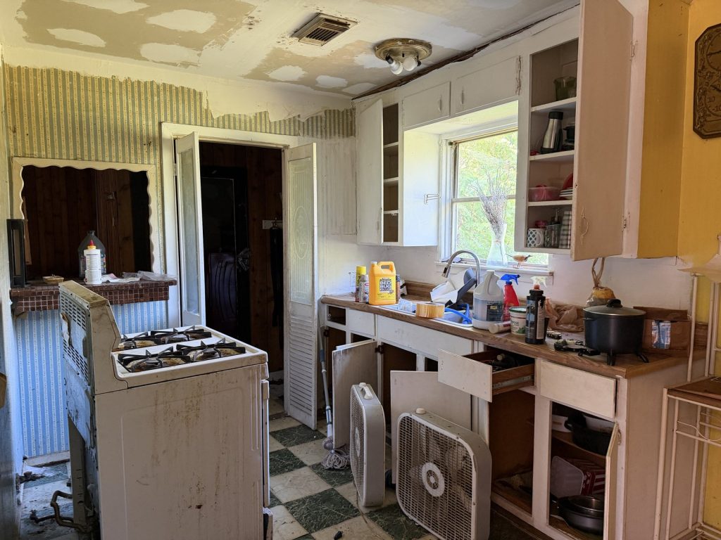 Dated kitchen with pest treatment supplies inside a Northwood Manor, Houston home purchased for cash