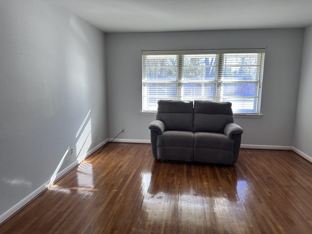 Living room with original hardwood floors in Spring Branch Houston TX home sold as-is
