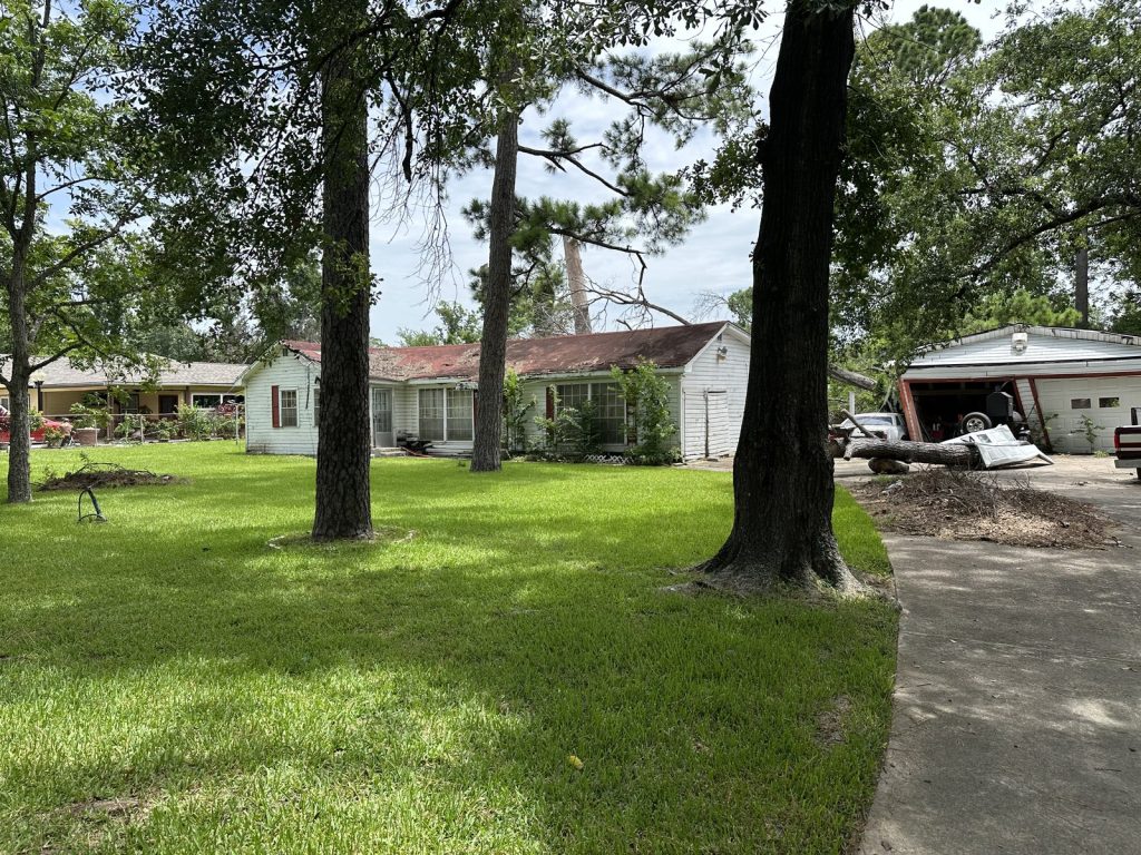 Front yard and storm debris at a tree-damaged Houston Gardens, Houston property sold as-is
