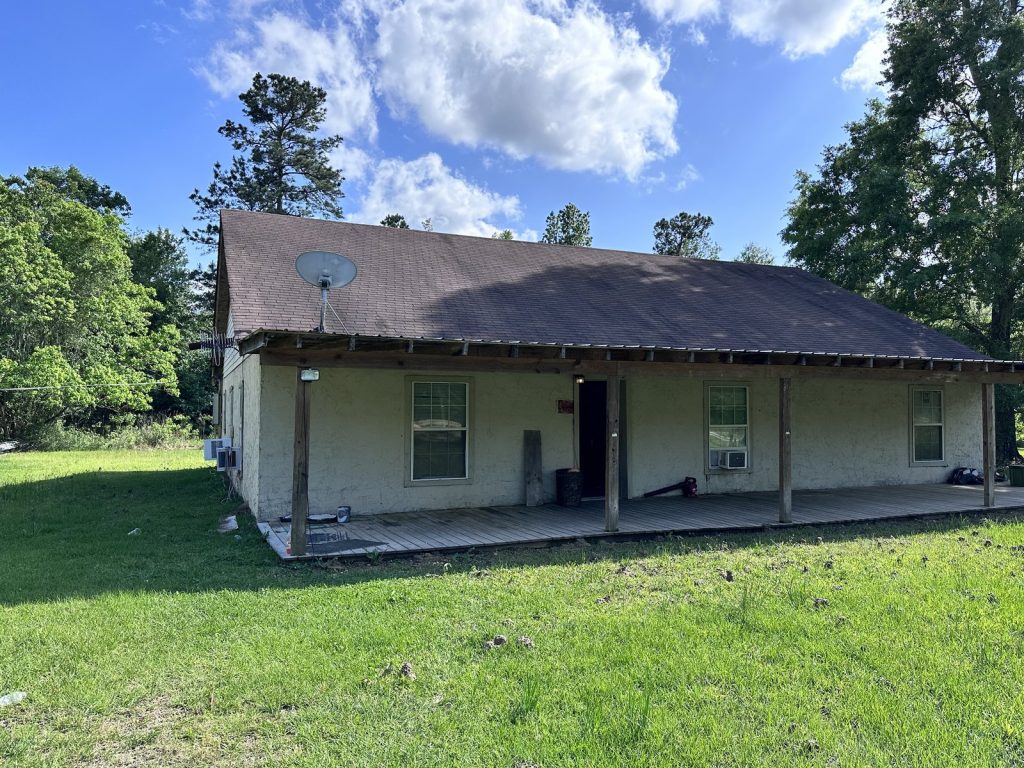 Wraparound porch of a distressed rural home purchased for cash in Cleveland, TX
