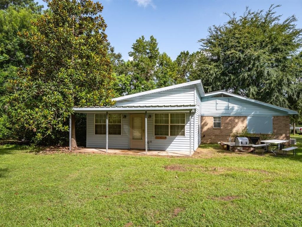 Side exterior of a vacant rural home purchased for cash in Cleveland, TX