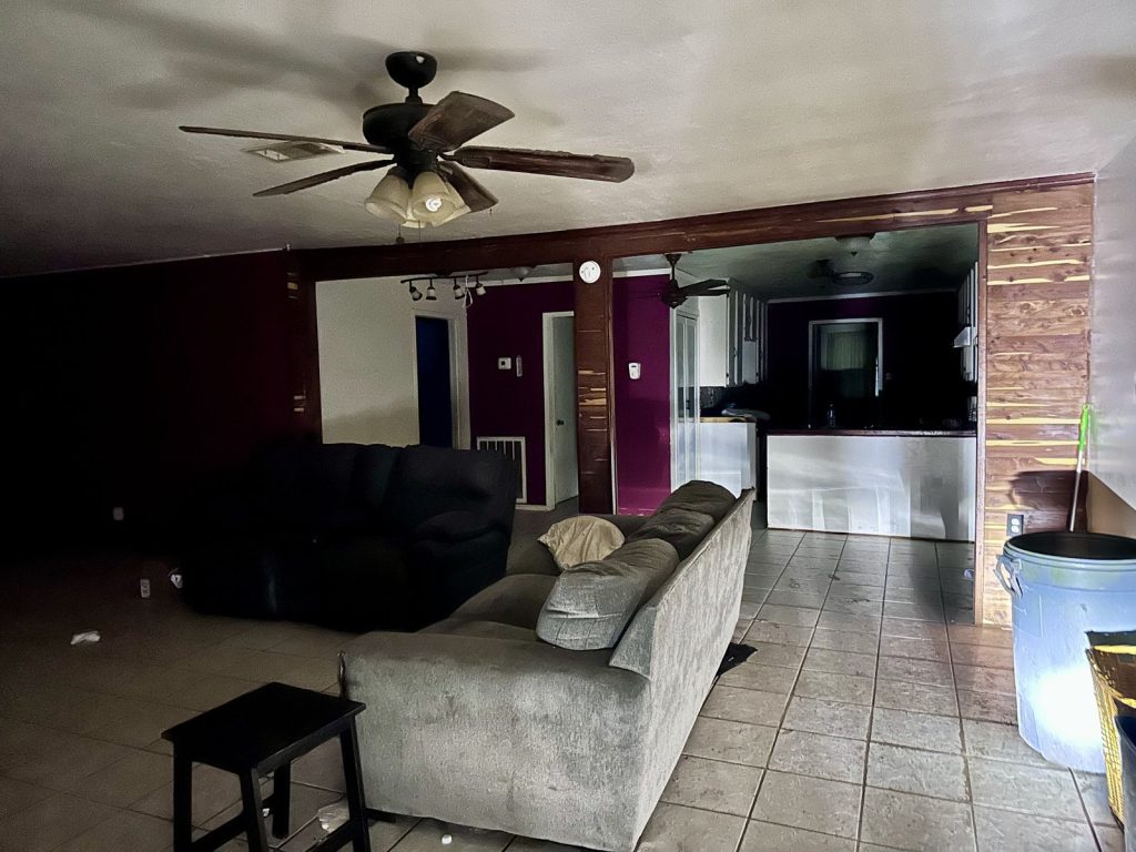 Empty living room and kitchen in a vacant property sold for cash in Cleveland, TX