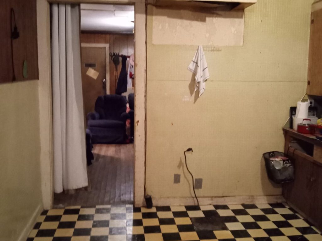 Interior hallway of a rural home with maintenance issues sold for cash in Cleveland, TX