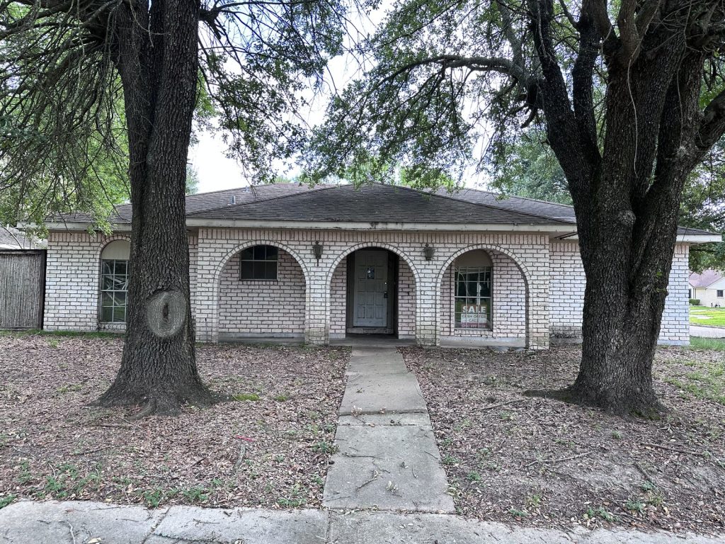 Front exterior of a hoarder house with foundation issues in Greater Inwood, Houston TX bought for cash