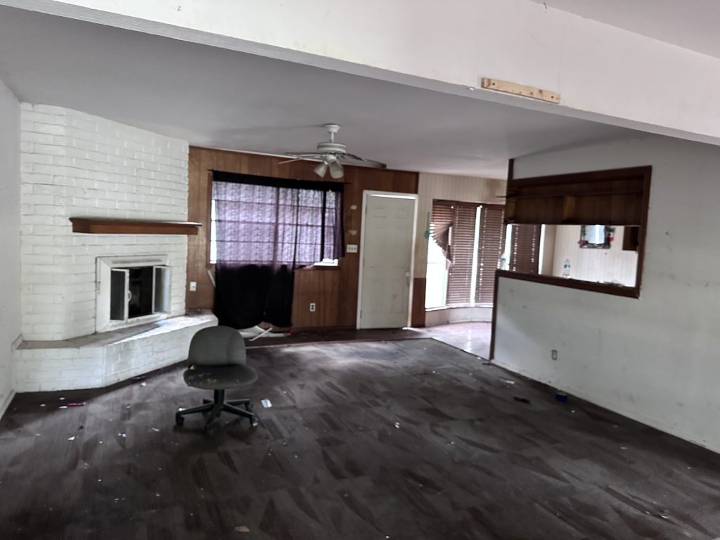 Cluttered living room inside a Greater Inwood, Houston hoarder house sold as-is