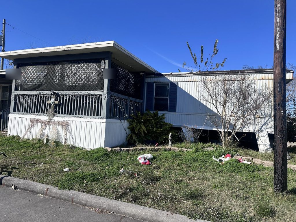 Older single-wide mobile home with covered porch sold as-is in Deer Park TX