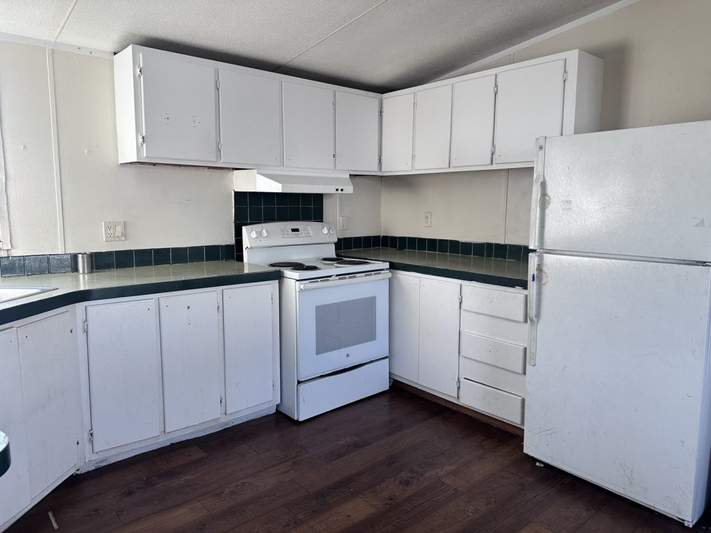 Dated kitchen inside mobile home rental purchased as-is in Deer Park TX