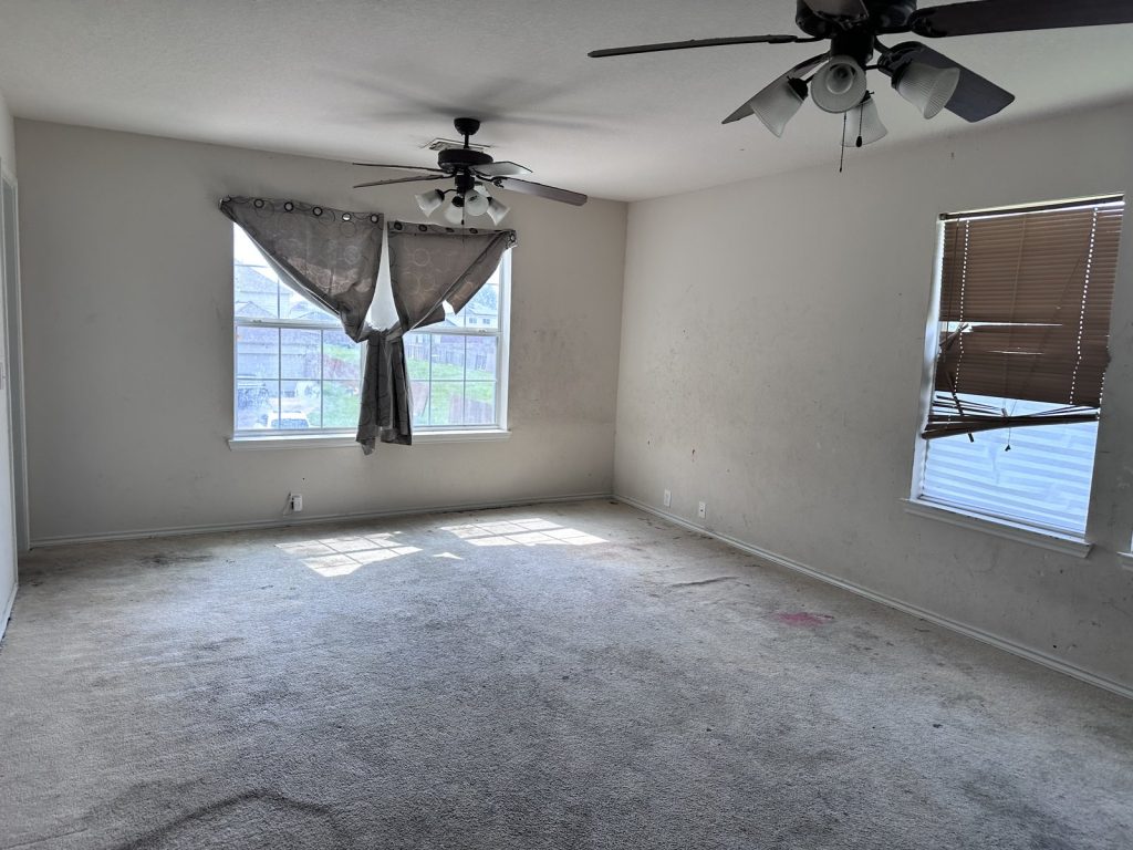 Stained living room carpet in a vacant Winfield Lakes home sold for cash