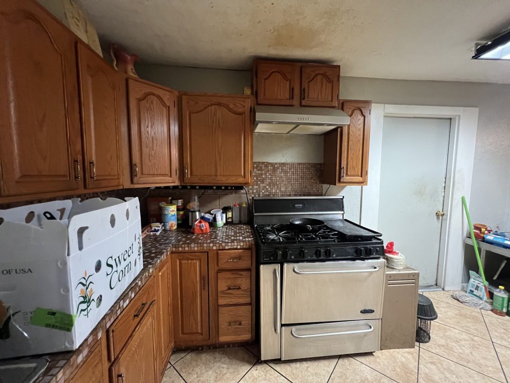 Kitchen with ceiling staining from plumbing issues in Houston TX home sold as-is