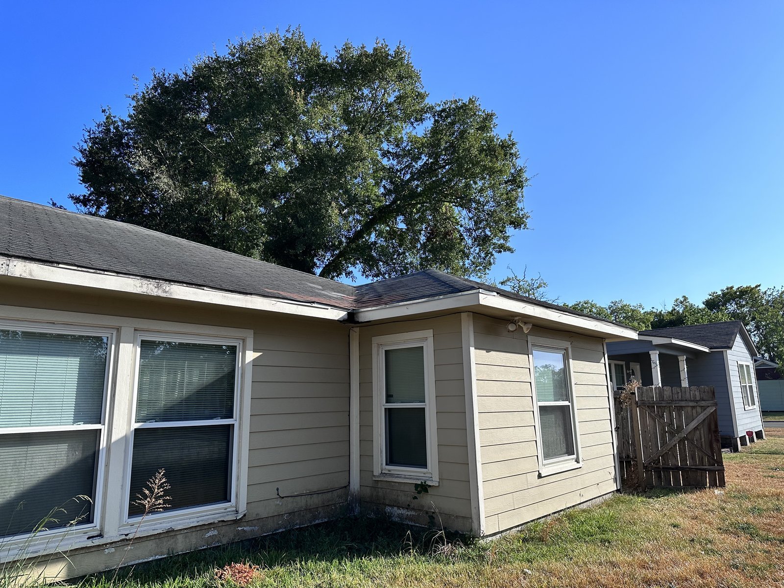 Side exterior of well-kept tan home bought for cash in Britton Cravens, Baytown TX