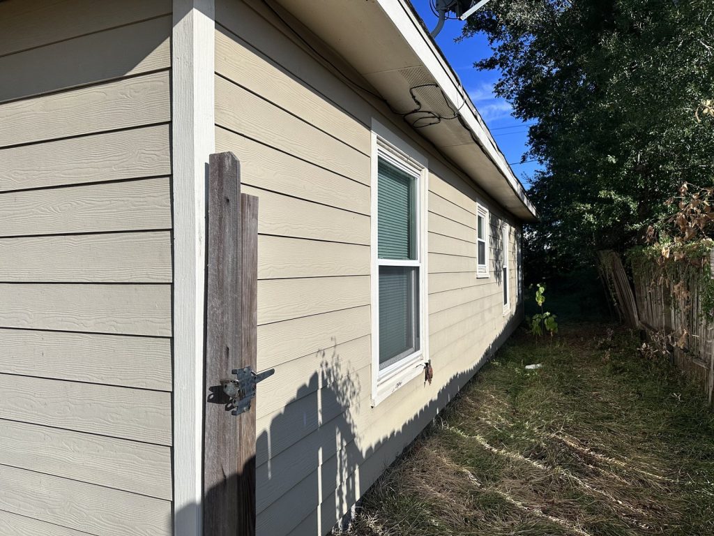 Side yard and windows of Baytown TX home purchased for cash by Volcan Property Buyers