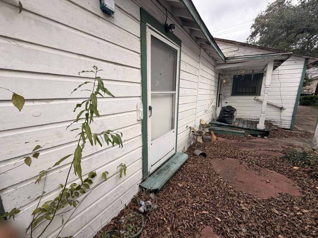 Side porch with peeling paint on probate property sold for cash in Houston TX