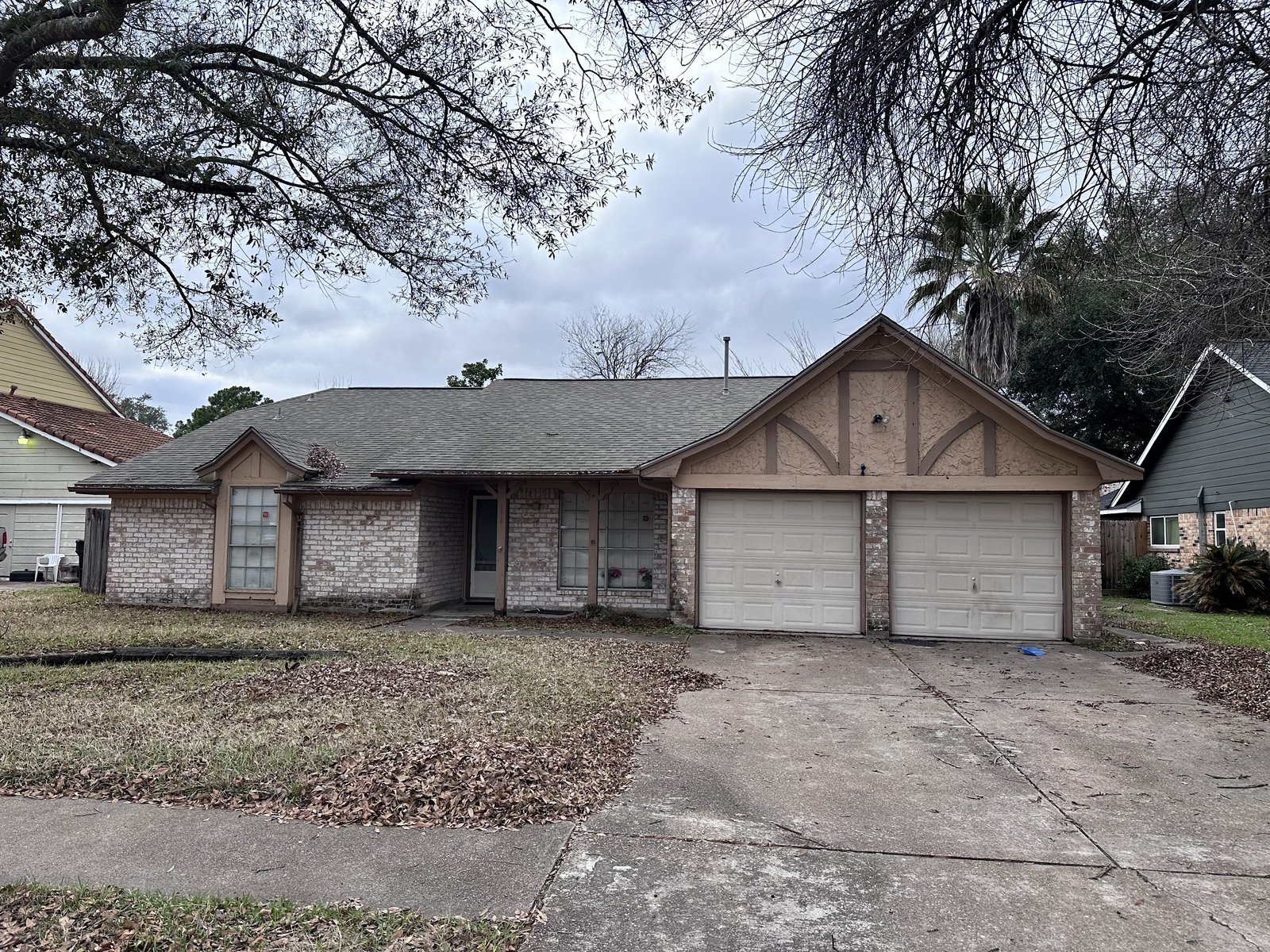 Front exterior of a storm-damaged home in Inwood Estates, Houston TX bought for cash