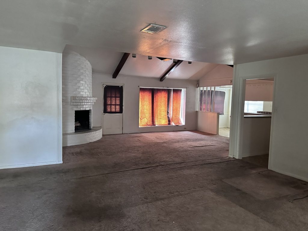 Living room with fireplace inside an Inwood Estates, Houston home purchased for cash