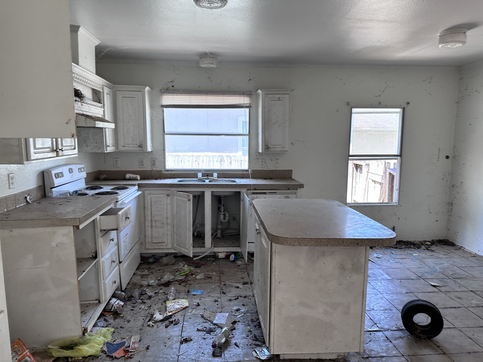 Rear yard view of a vandalized rental home in Greensbrook Place, Houston TX bought for cash