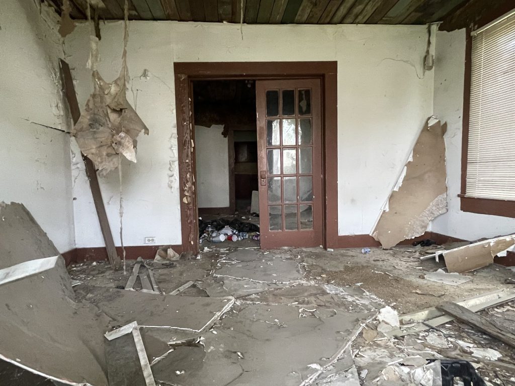 Deteriorated living room at a Fifth Ward home in East Houston, TX sold for cash