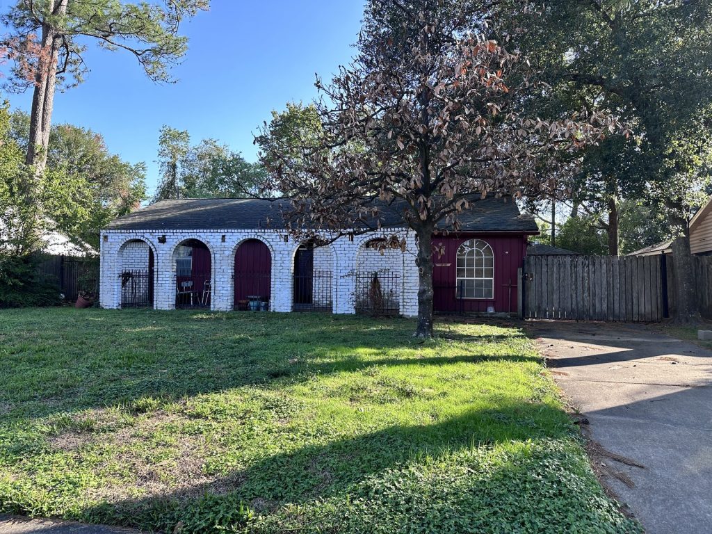 Arched brick carport at a Greater Inwood, Houston property sold as-is
