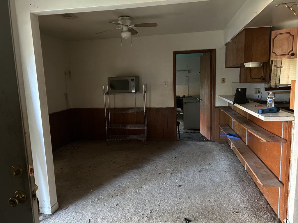 Empty living room in an abandoned home sold for cash in Willow Run, Houston, TX