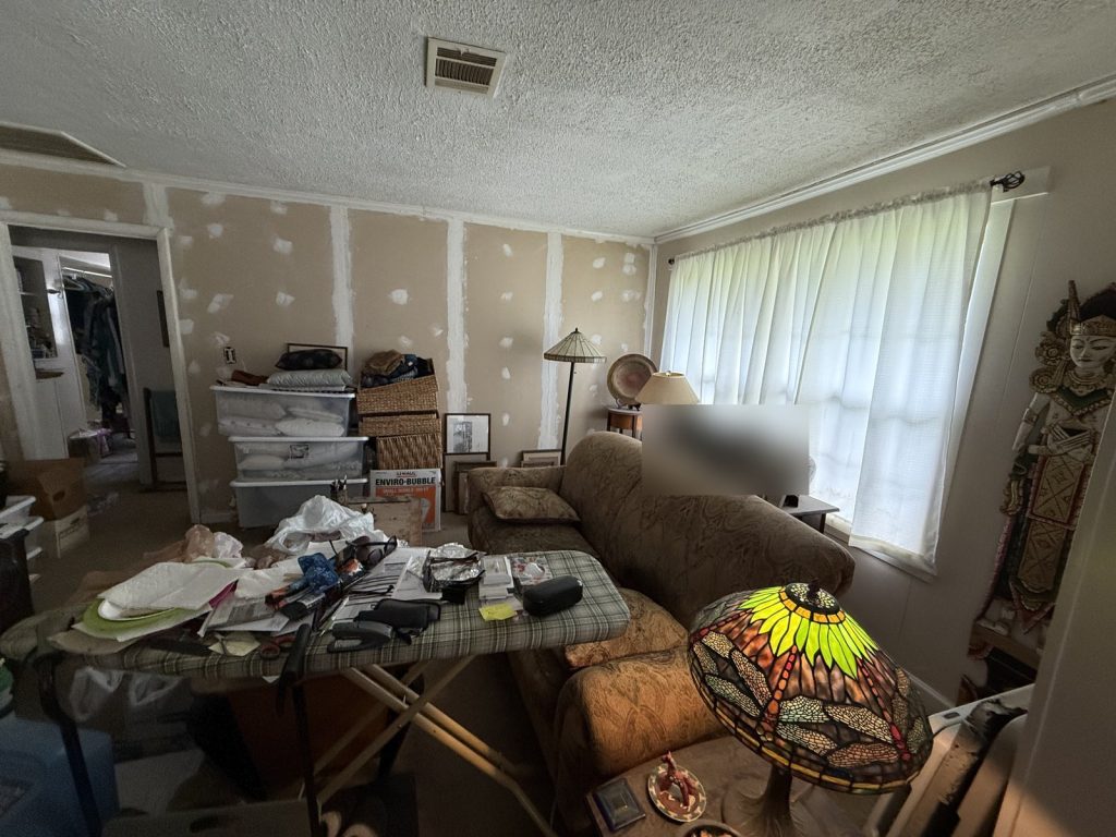 Living room with unfinished wall repairs in Houston TX home purchased for cash
