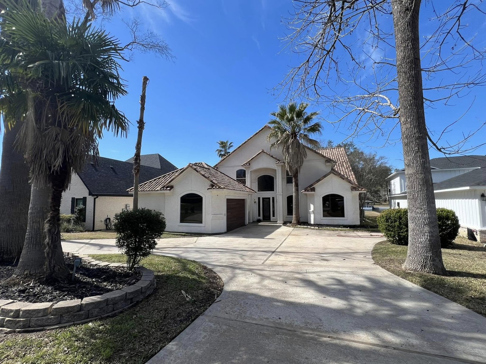 Front exterior of a two-story lake-community home in Point Aquarius, Willis TX sold through probate