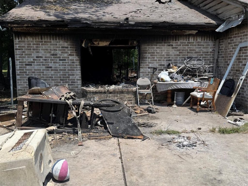 Fire-damaged brick exterior of an abandoned home in East Little York, Houston TX bought for cash