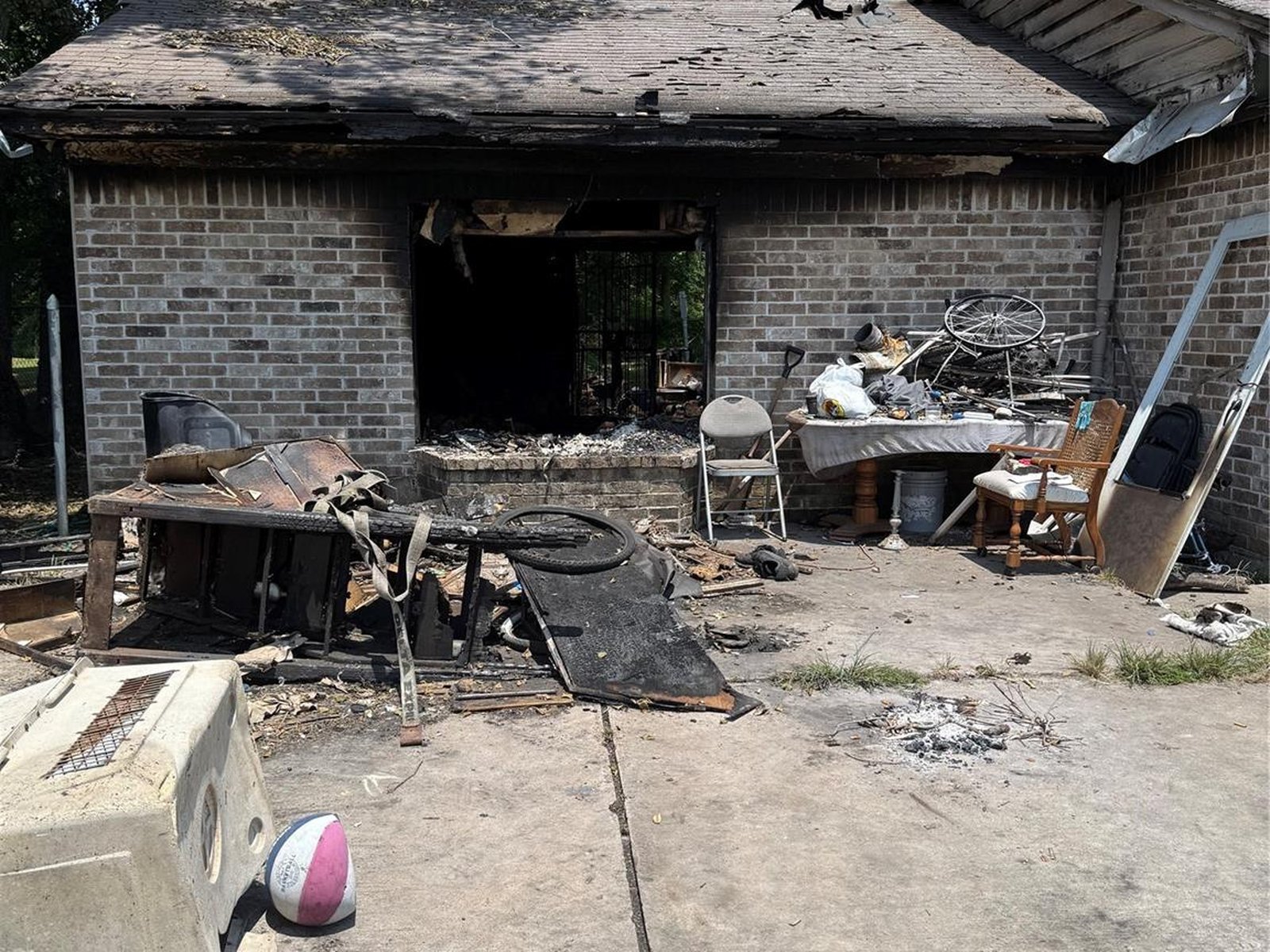 Fire-damaged brick exterior of an abandoned home in East Little York, Houston TX bought for cash